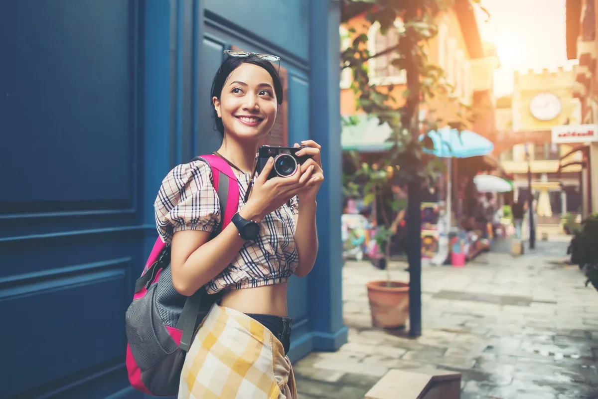 A young traveller with a camera exploring the city